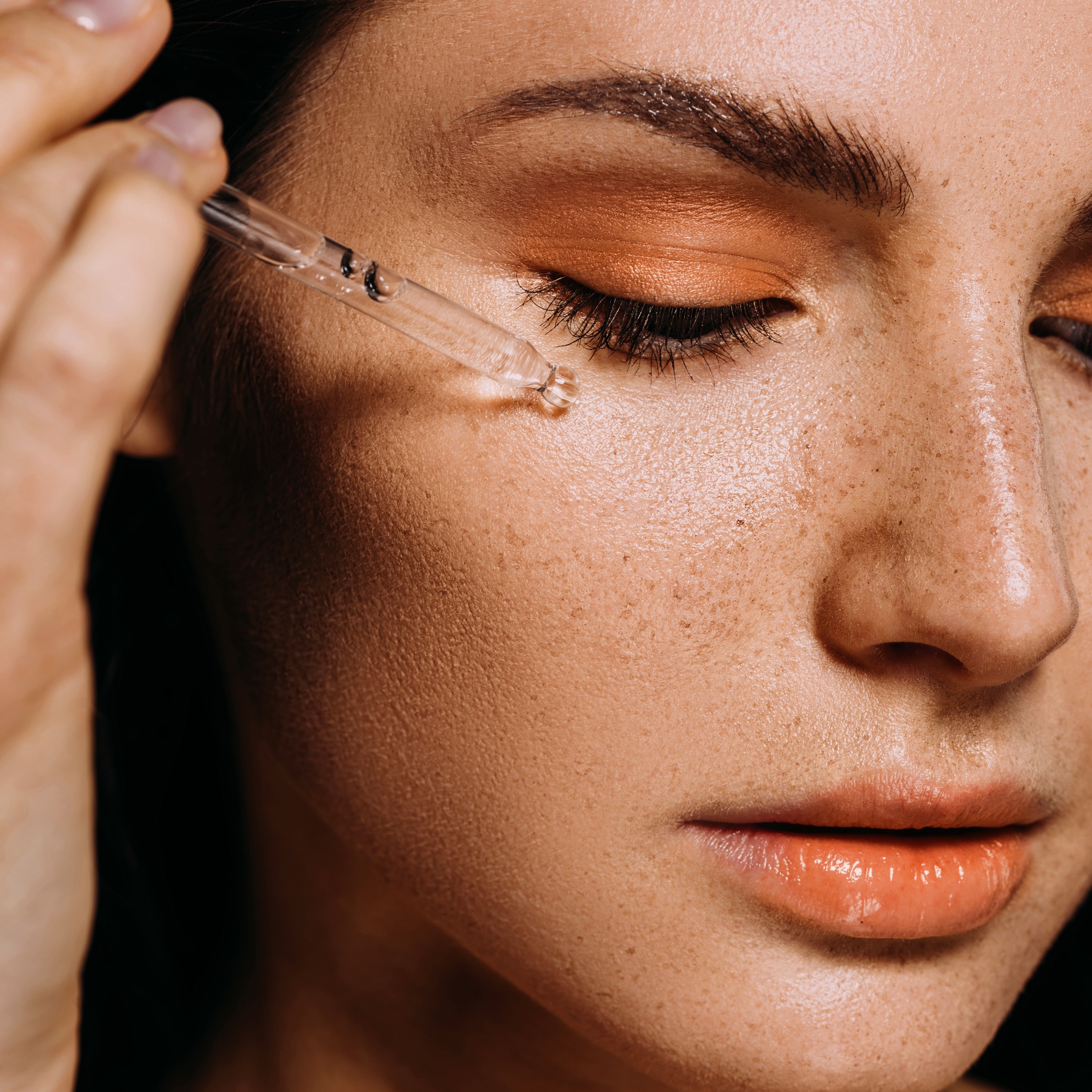 Professional applying a cosmetic serum to the face